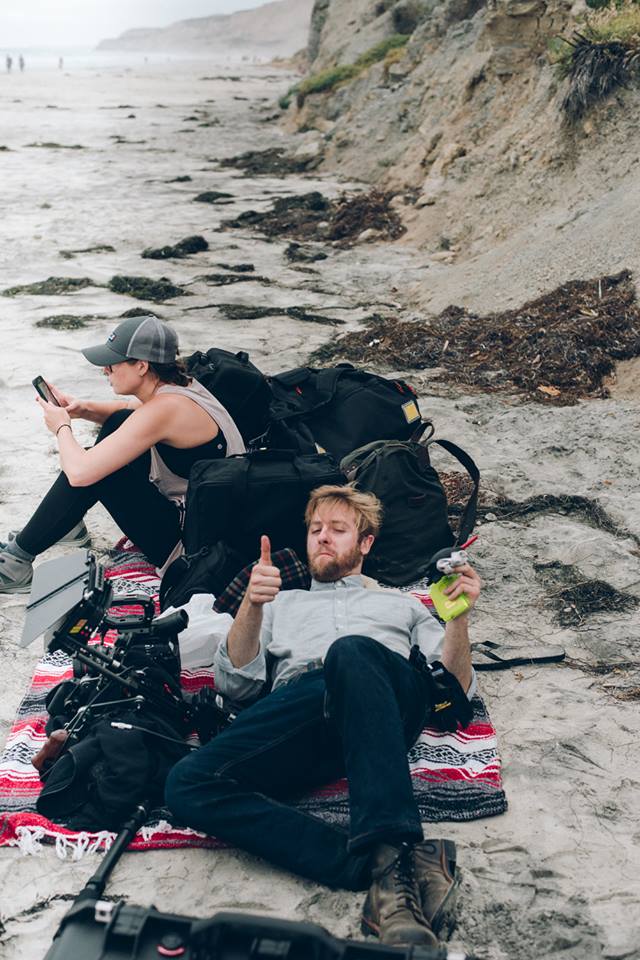 Dan, our Director of Photography, doing an Assistant Camera's job by preparing the camera. Behind him, Steph, who helped as a Production Assistant and Makeup on the first day. Photo by Clint Hess.