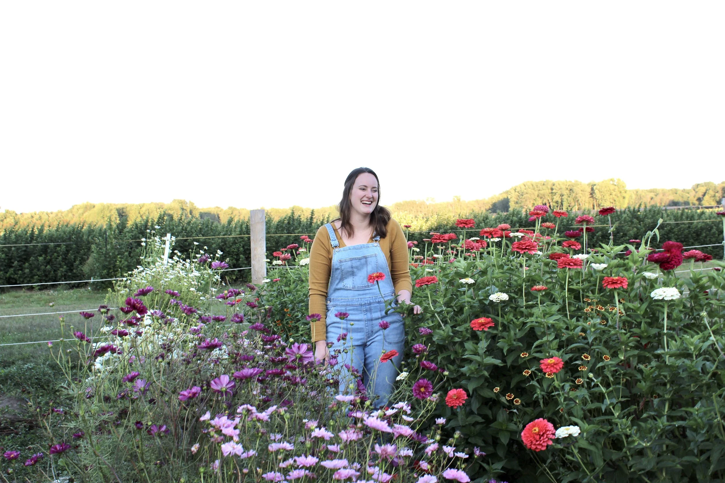 Female farmer standing in a field of flowers