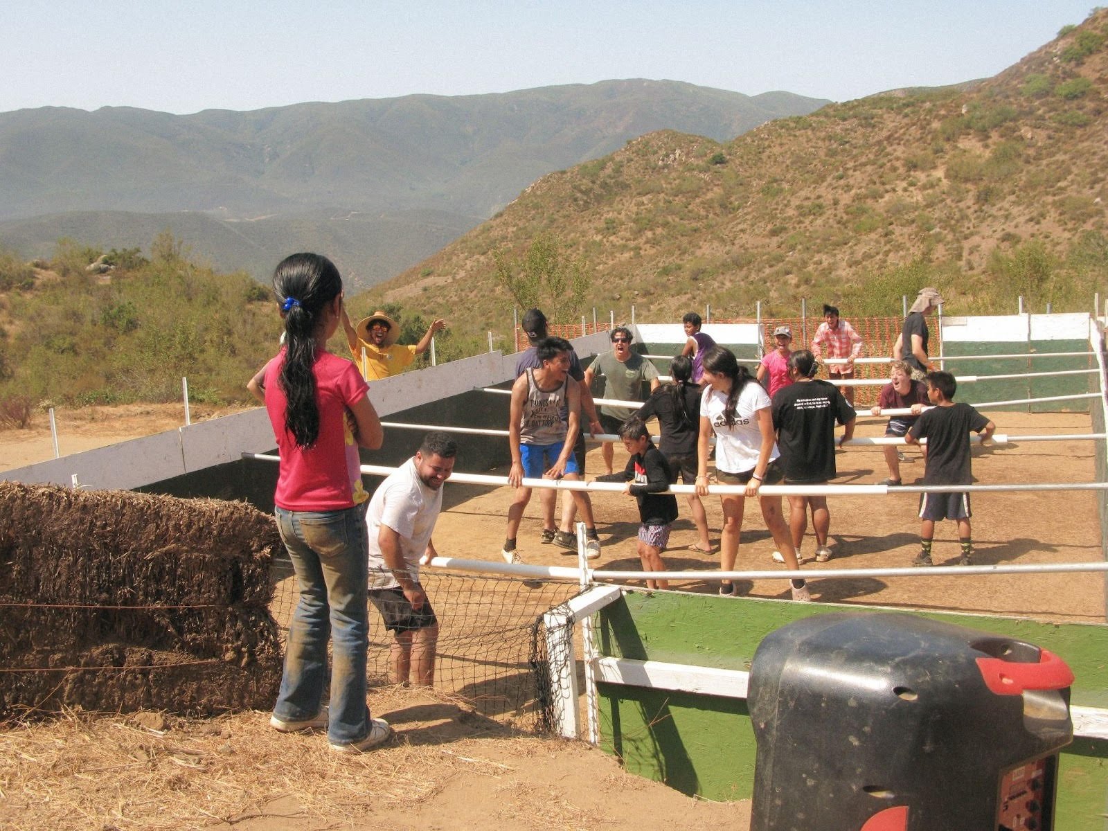 A group of kids playing soccer on a small dirt field
