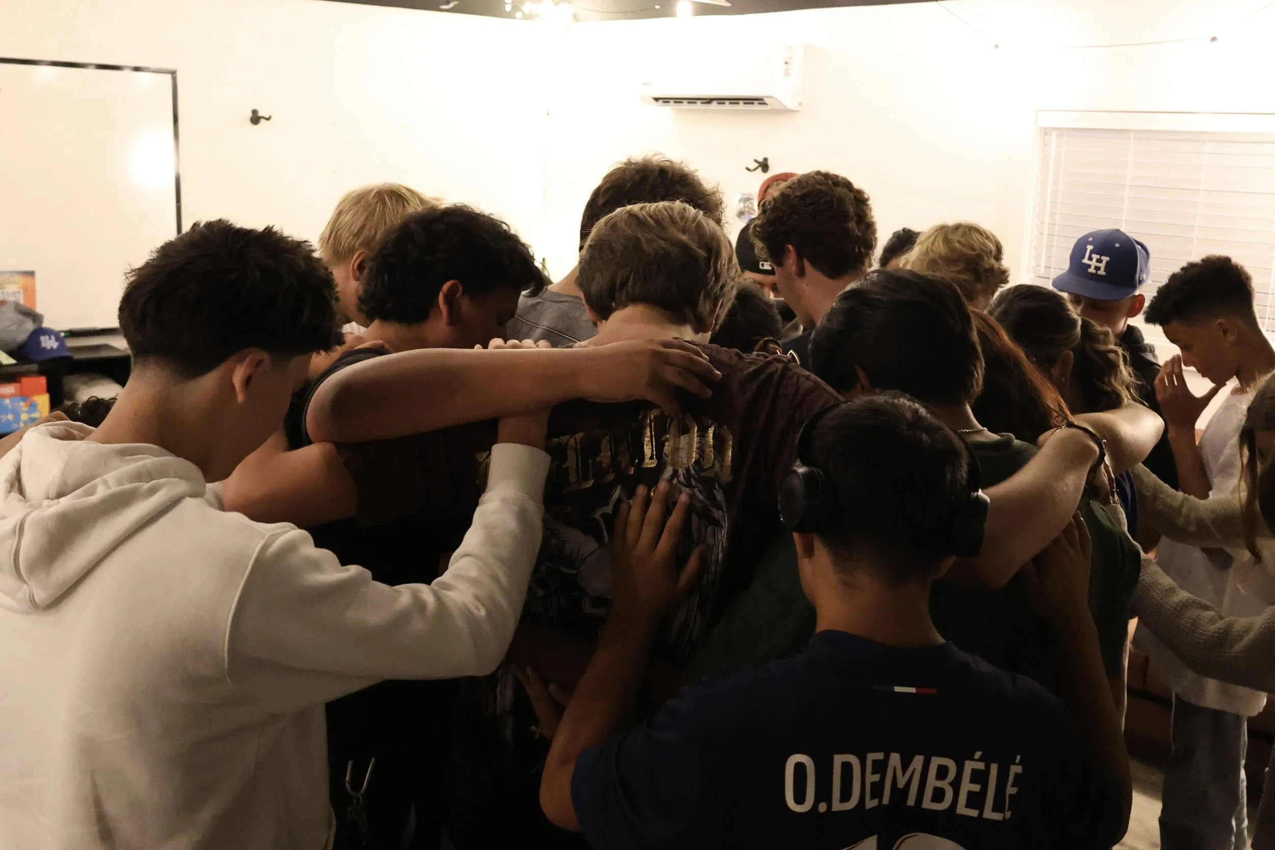 Junior high and high school students praying as a group