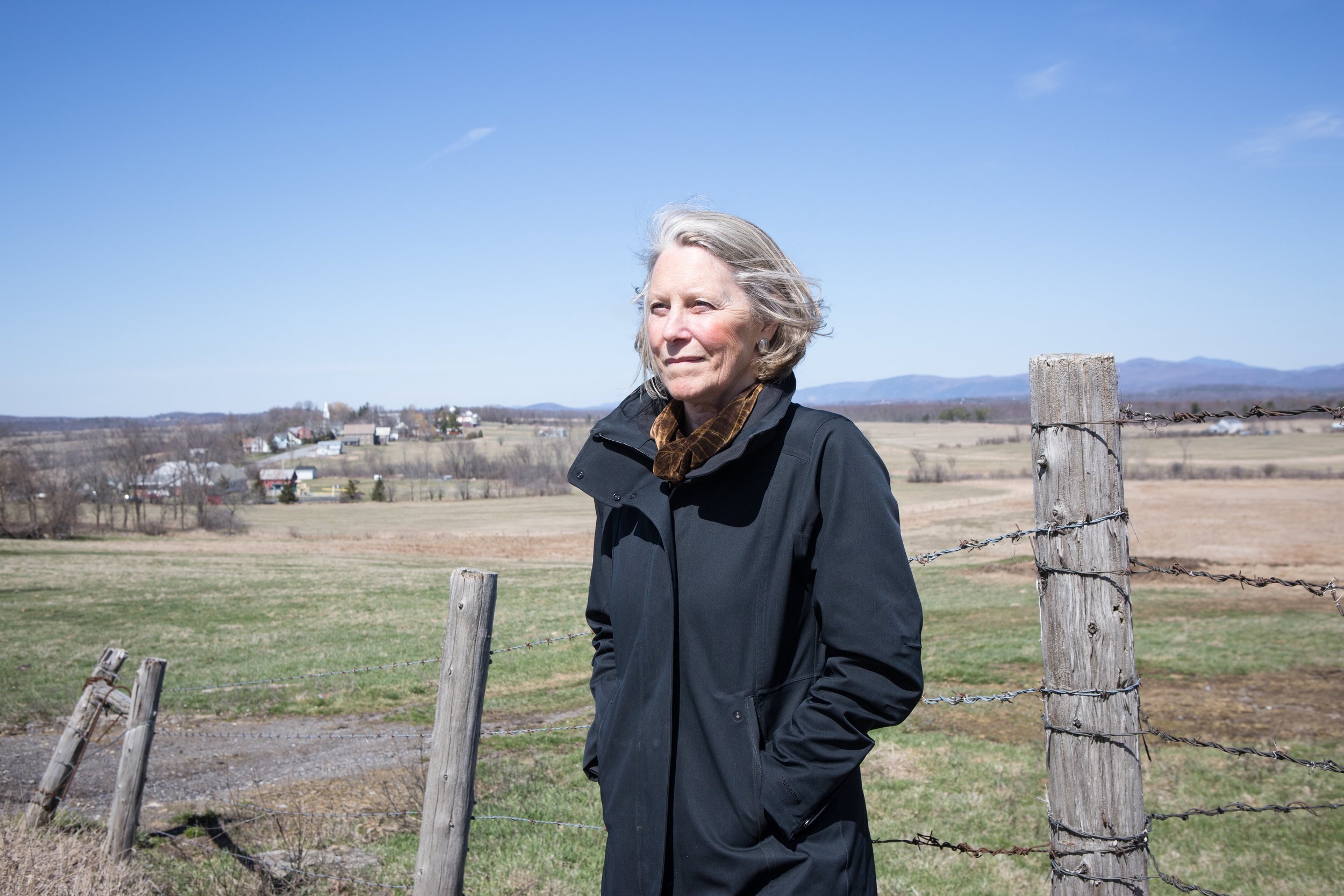 Elizabeth Courtney overlooking the village of Whiting, VT–a landscape view that demonstrates the land use pattern of compact village settlement surrounded by open working landscapes, long established as a hallmark of smart growth in Vermont. This pattern was a cornerstone issue during her tenure as Executive Director of the VNRC and continues to be an important environmental and energy policy to protect our forests, farm lands, and water resources while accommodating new growth in our town centers and downtowns.