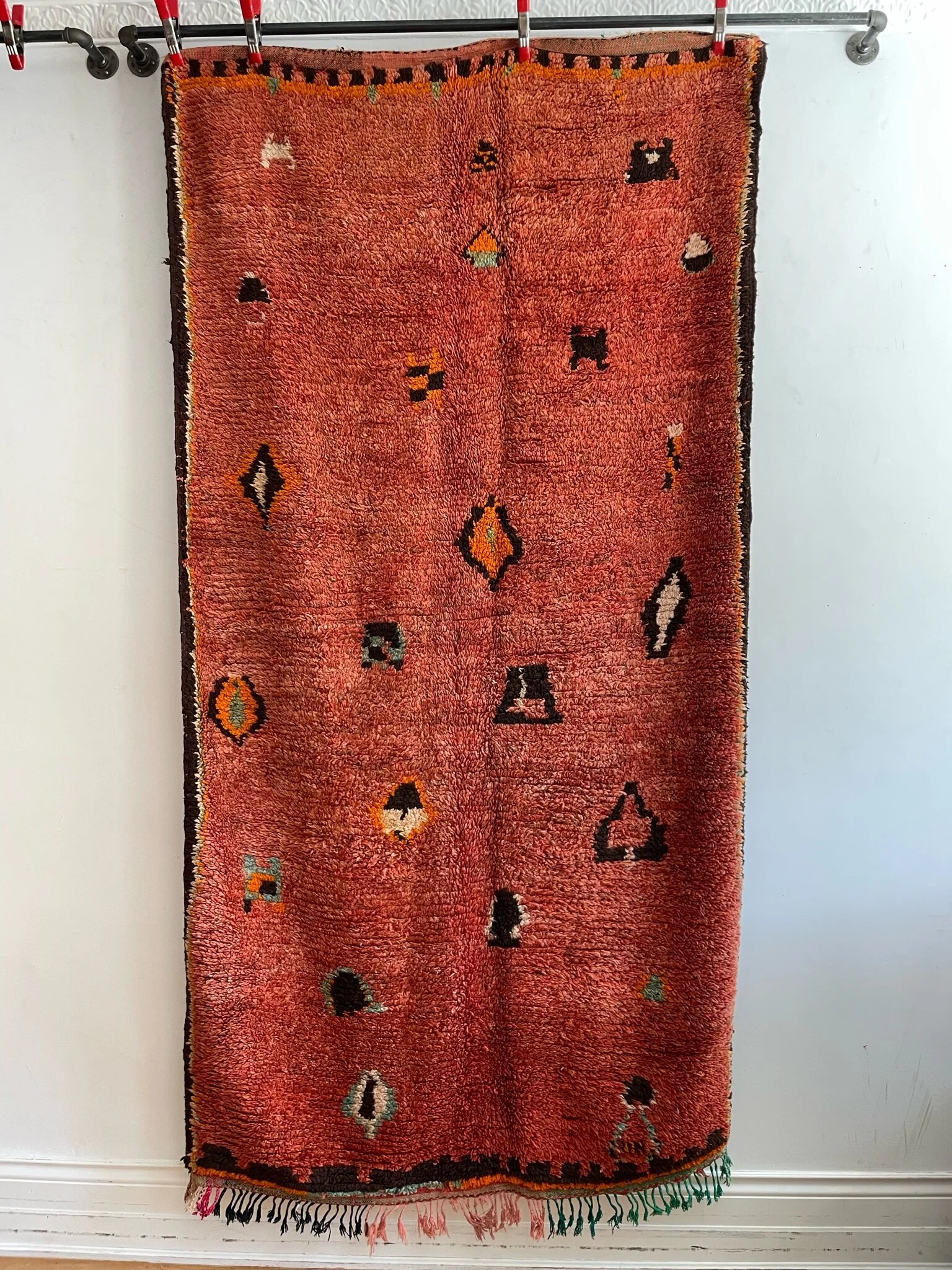 Brick red vintage Moroccan hand knotted wool rug with cute shapes and brown borders