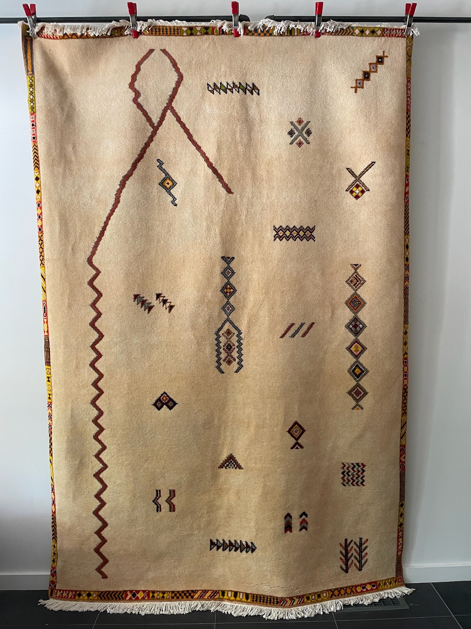 low-pile, hand-knotted cream Moroccan wool rug with orange and brown minimal Berber designs