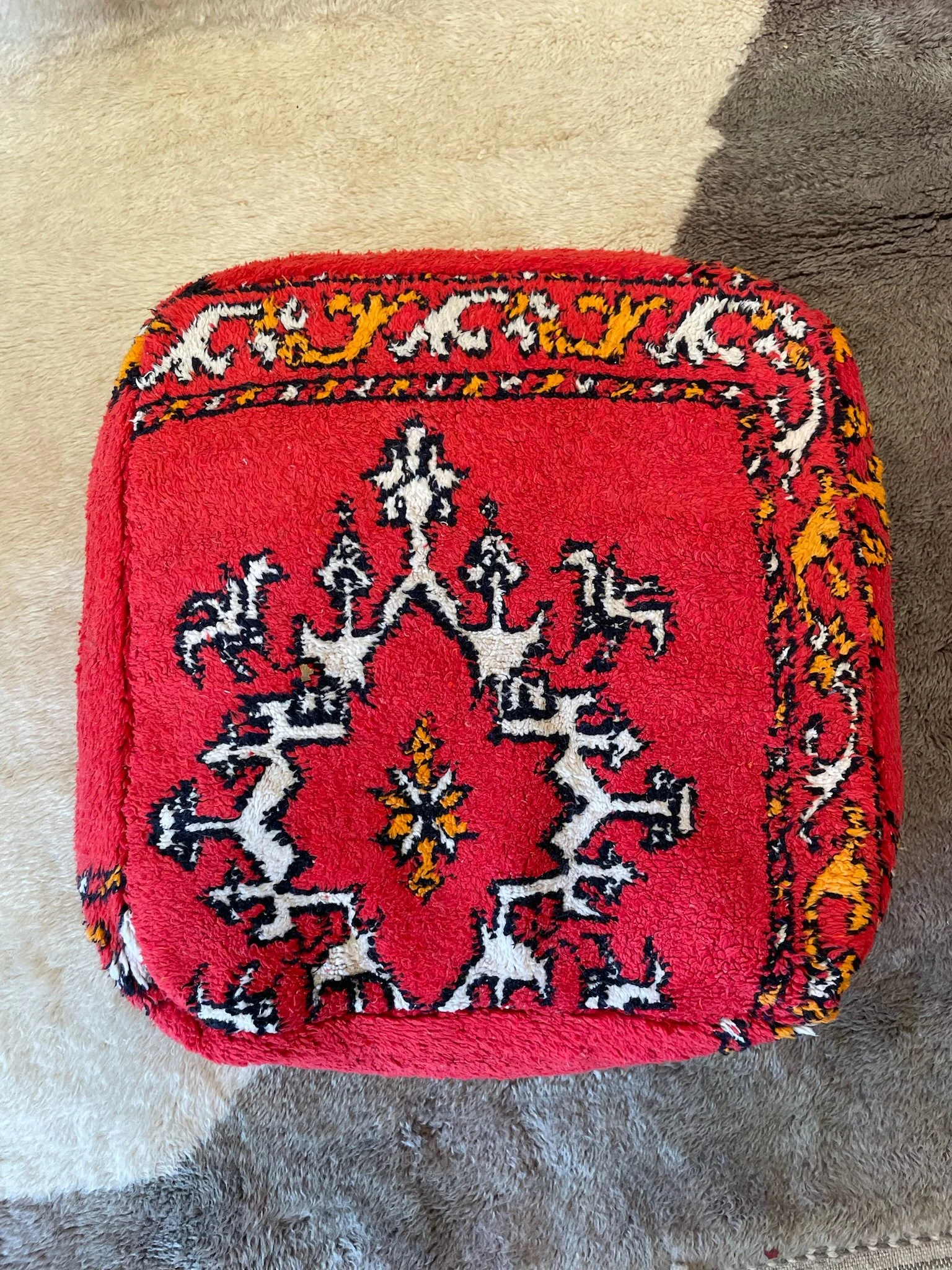 Bright red Moroccan floor cushion with white and orange designs