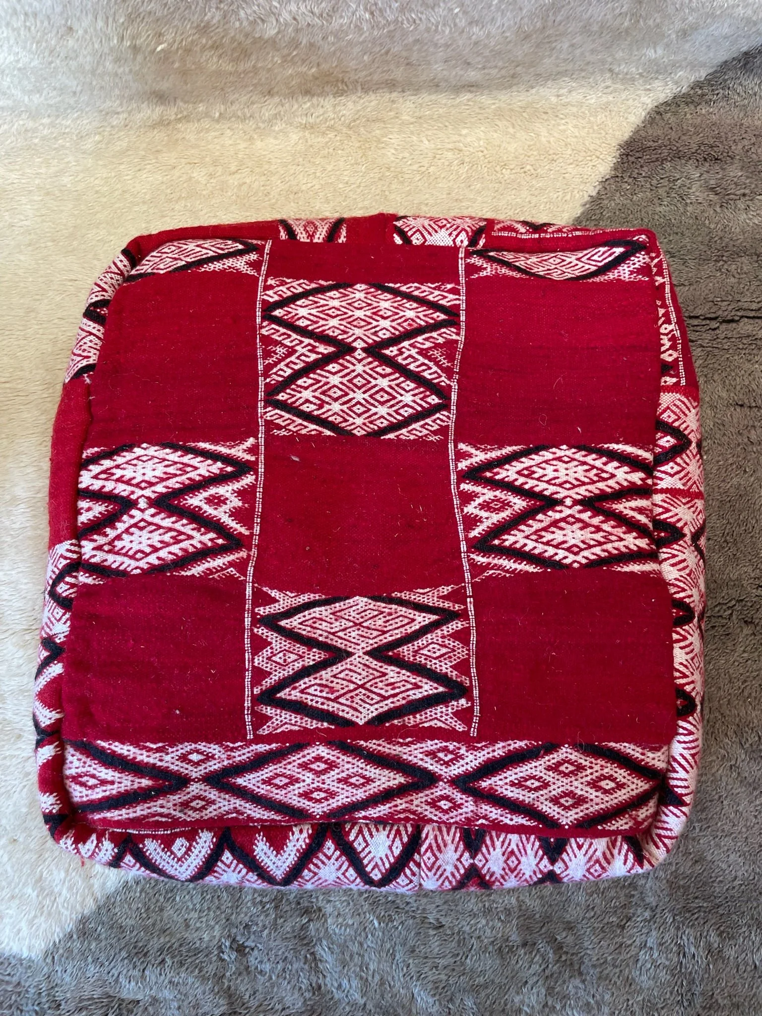 Red Moroccan floor cushion with black and white checkerboard pattern design