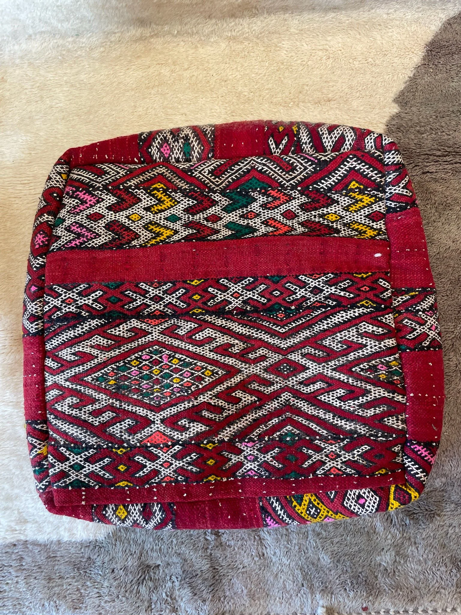 Red Moroccan floor pillow with white, green, orange, yellow and pink embroidery