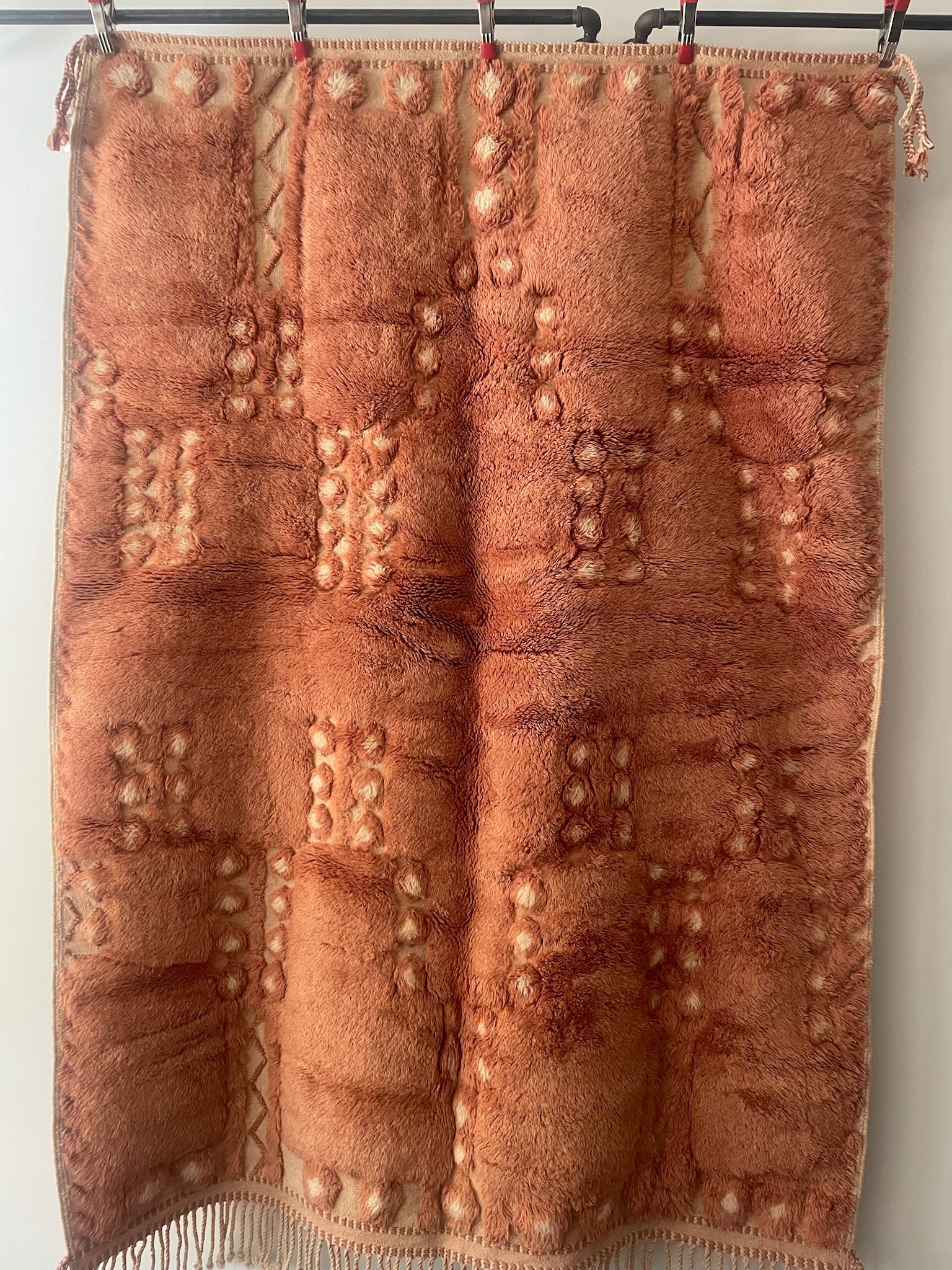 Soft terracotta hand-knotted Moroccan wool rug with cream details