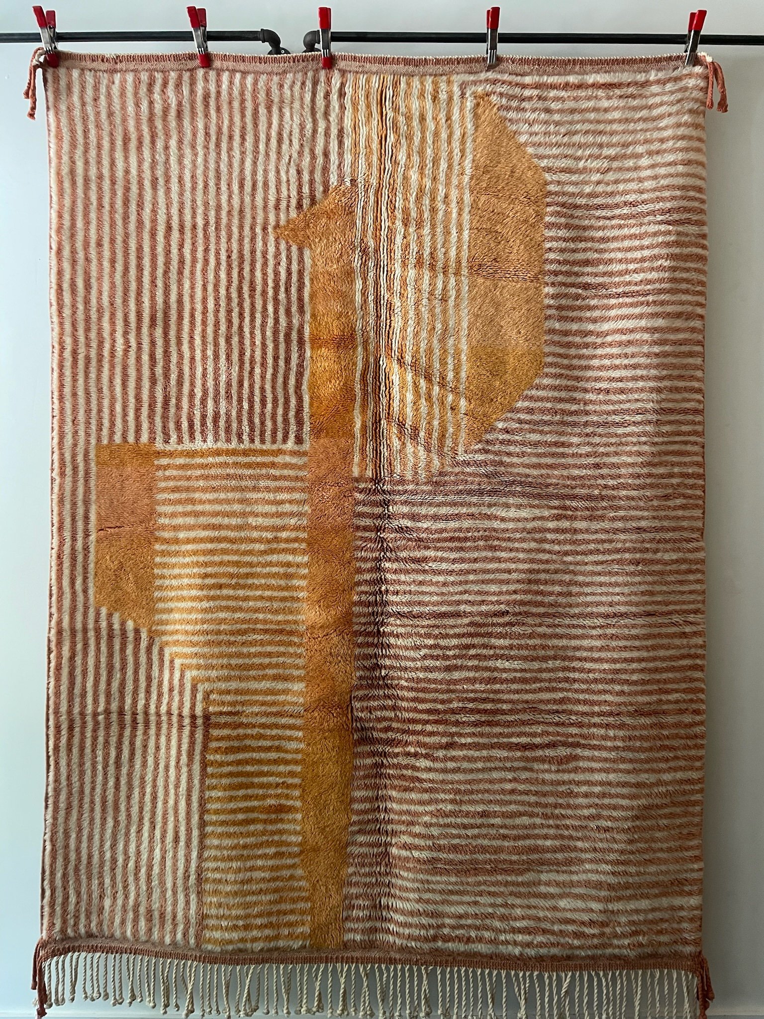 Modern hand-knotted Moroccan wool rug with tight cream and terracotta lines and orange design