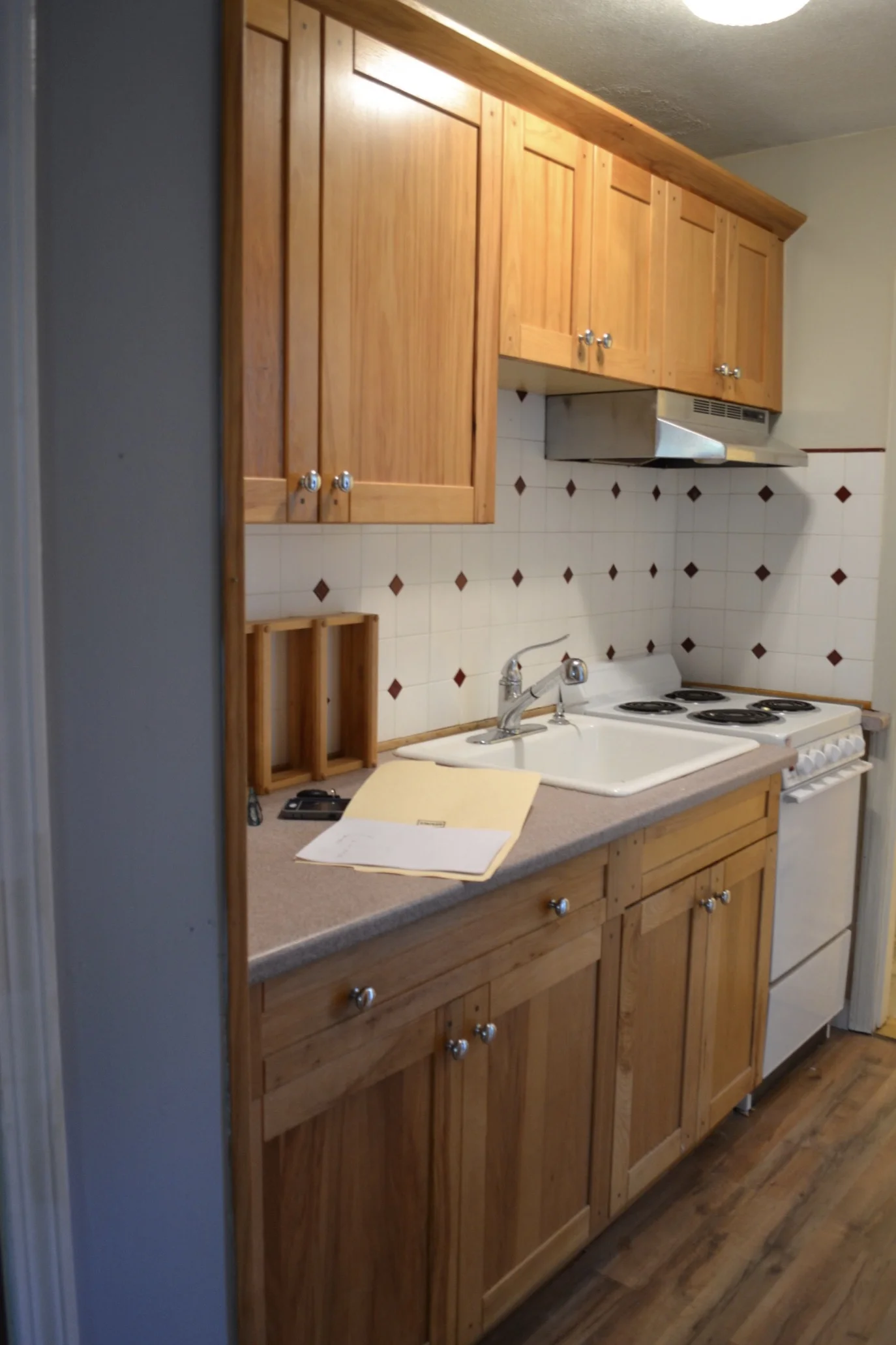 Condo Before-Galley Kitchen, laminate counter top, vinyl flooring backsplash.