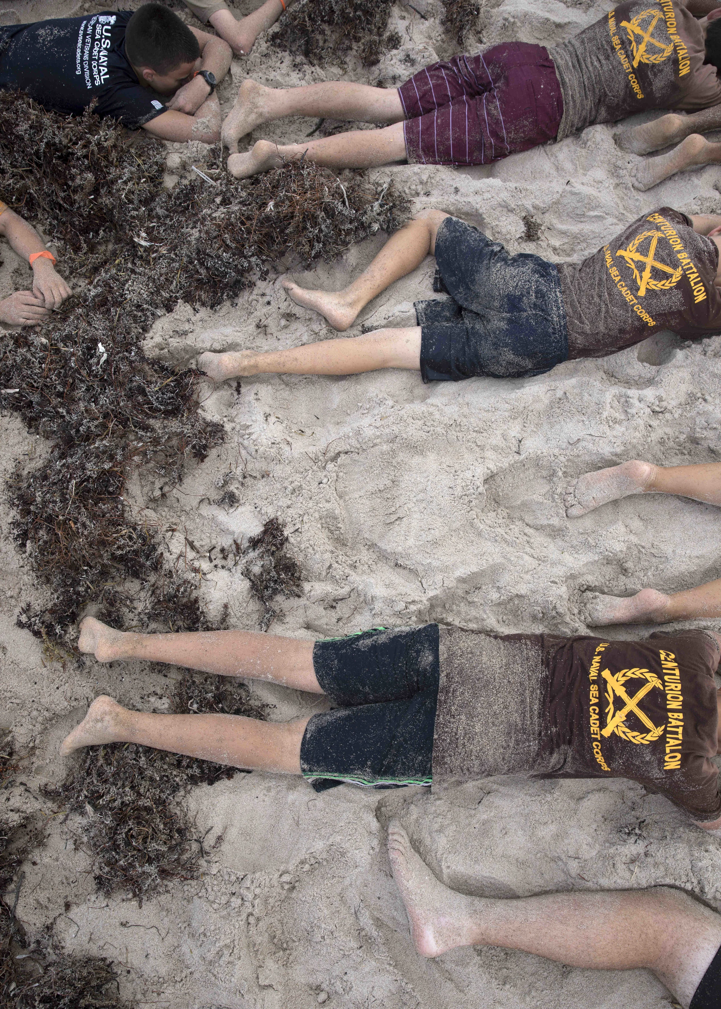  Sea Cadets wait for instructions during beach physical training. Once enrolled in the Sea Cadets, members must attend a mandatory two week training camp before they can join their local division. The curriculum is approved by the U.S. Navy and stand