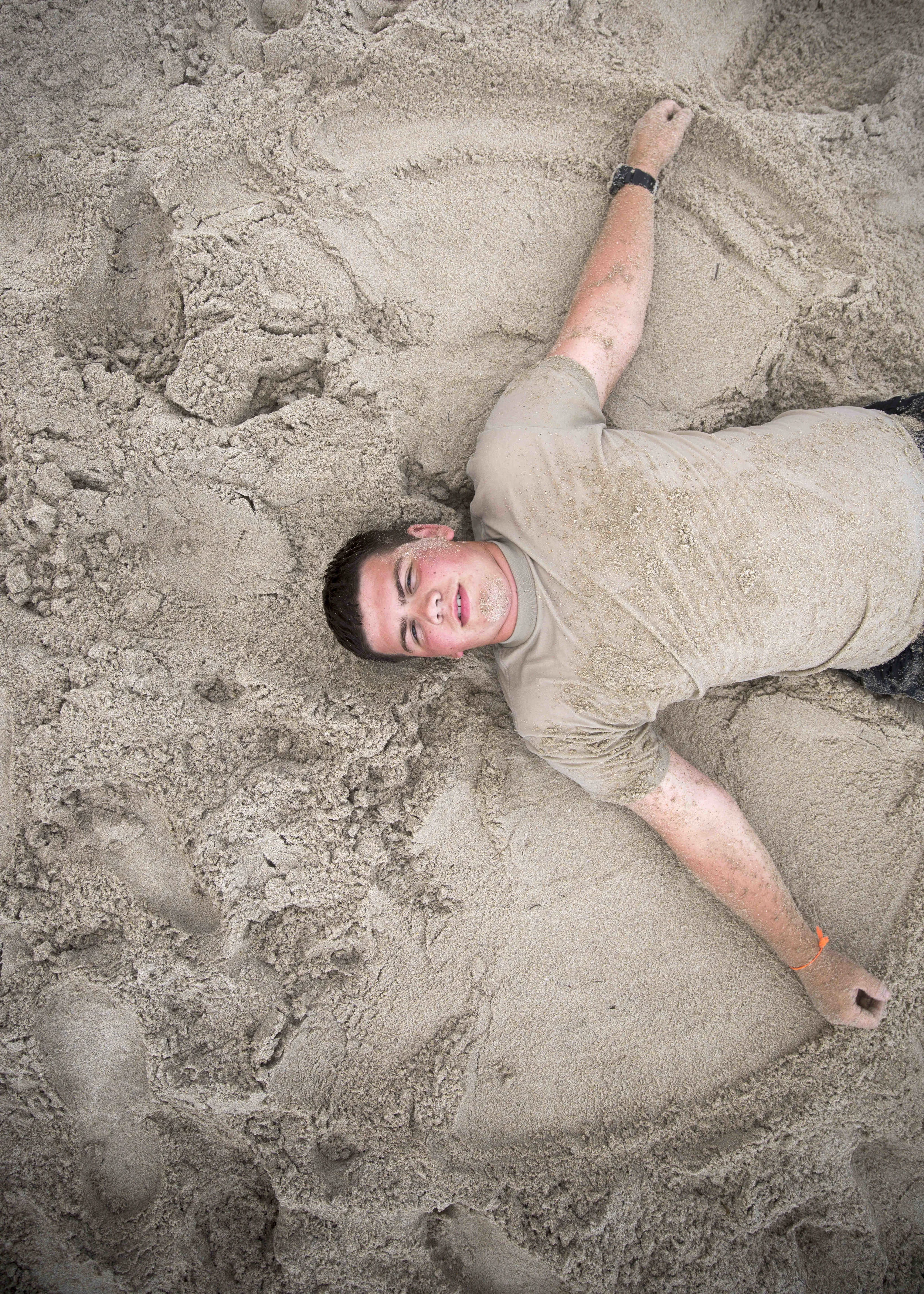  U.S. Naval Sea Cadet Corps Petty Officer 3rd Class Foster, Palm Beach Division, makes a "sand angel" during beach physical training.&nbsp; 
