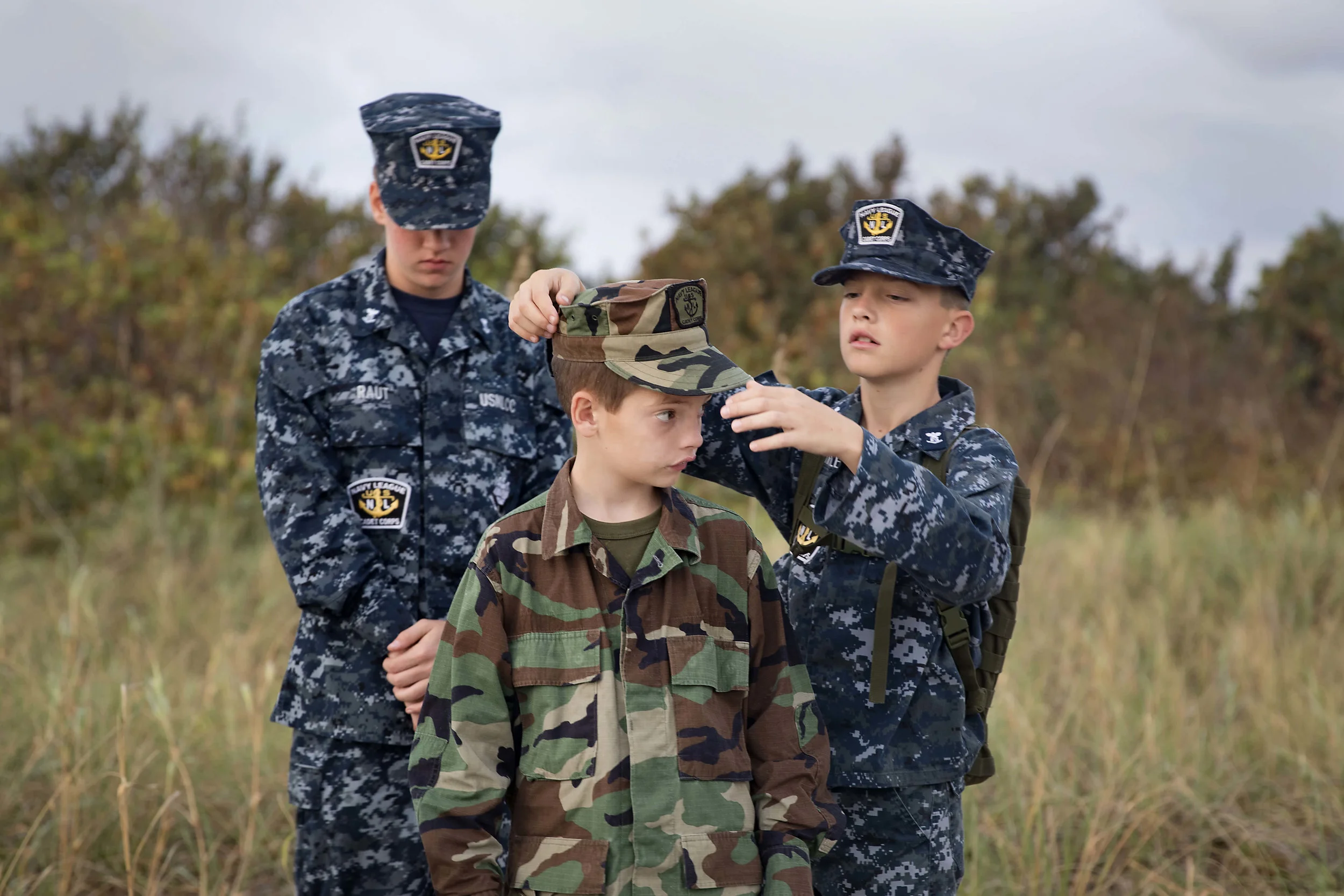  U.S. Naval Sea Cadet Corps Petty Officer 3rd Class  Schindele , Centurion Battalion, helps Recruit Cadet Ouvier, Palm Beach Division, prepare for a memorial service for former U.S. Navy SEALs who have died in 2016. During the ceremony, cadets provid