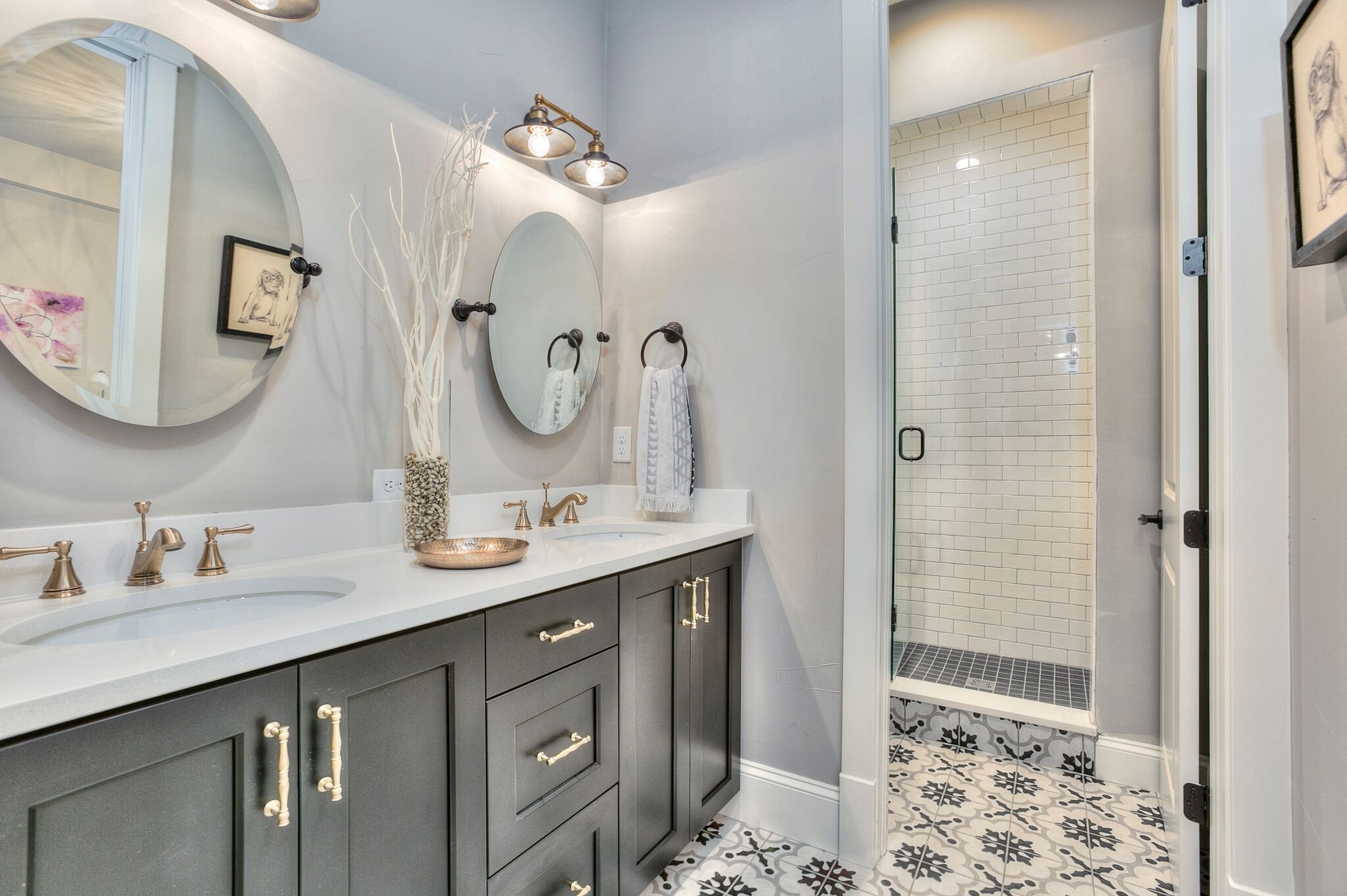 Custom dark vanity cabinetry with brass hardware and a white countertop