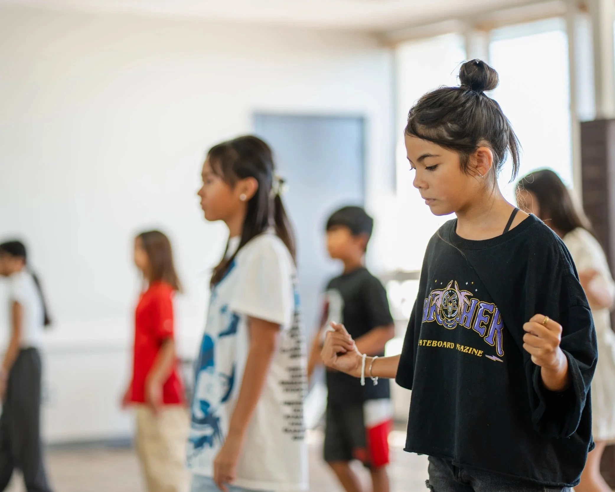 Children learning rhythm and choreography during a kids hip hop dance class at re.DEFINE Dance Studio in Hayward, California.