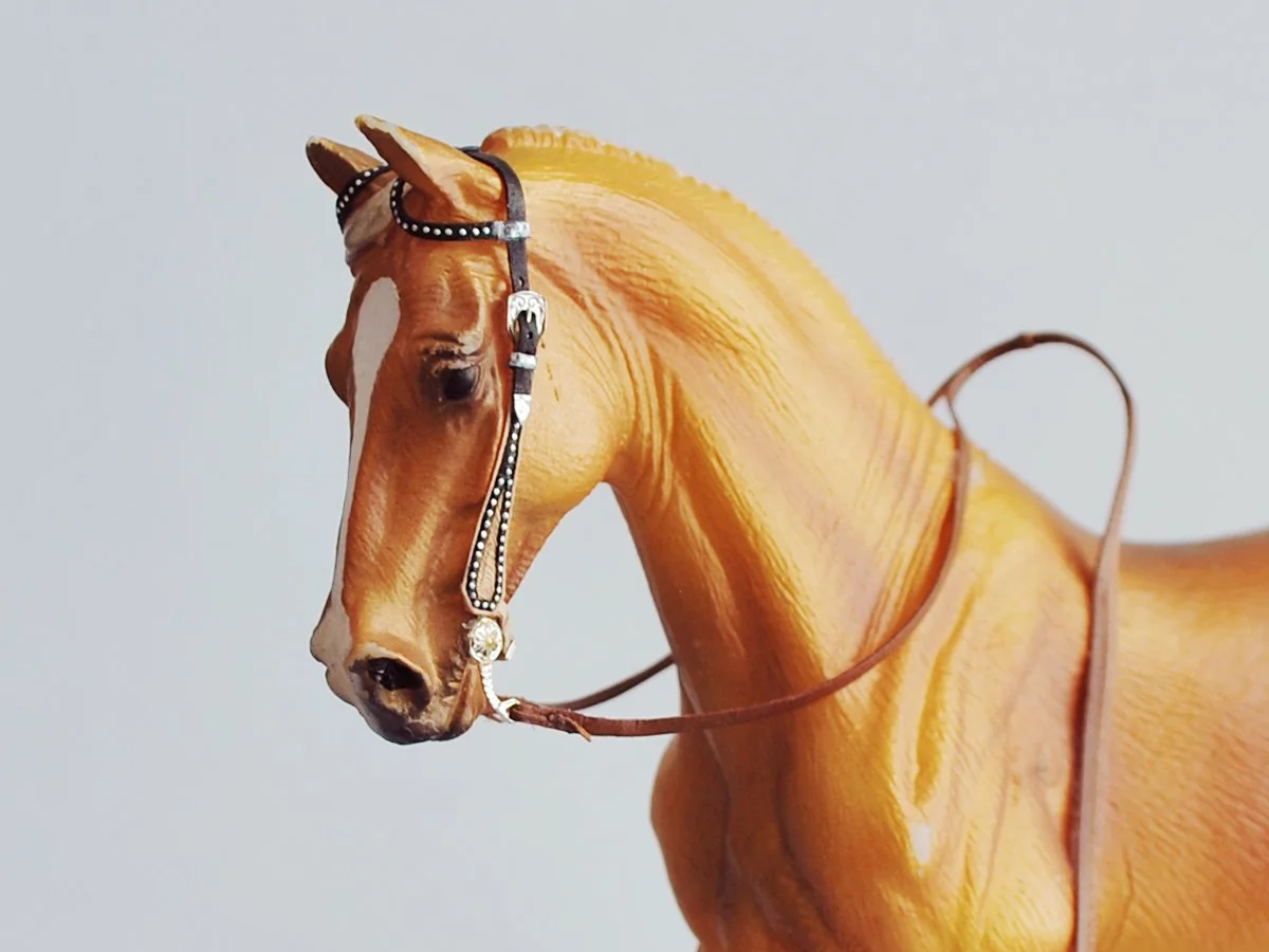  Light colored western bridle with black details and silver studs on a palomino horse 