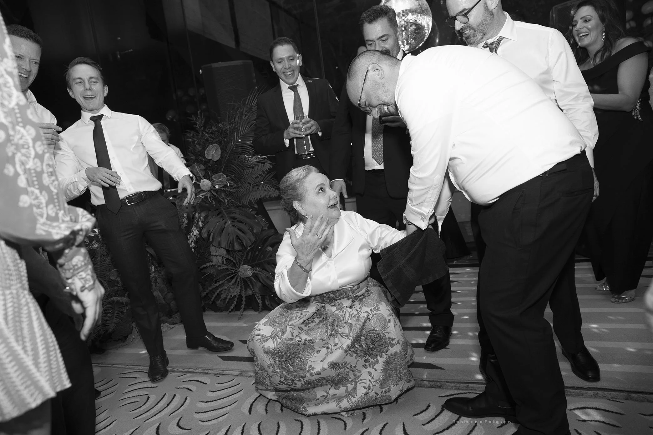  The groom helps his mother on the dance floor during the wedding reception.  