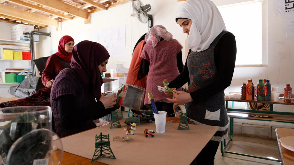Girls working on a "bad" city diorama using recycled materials and leftover, unused toy props. Often to get one specific toy, an entire bag or set had to be purchased, making for a lot of leftover pieces. Anything not used in War-Toys photos or these sessions were donated to Kayany Foundation schools. 