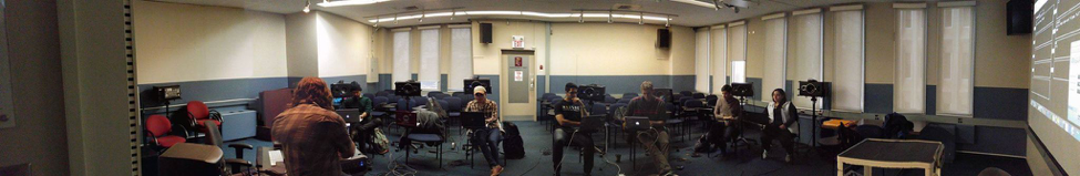 Figure SEQ Figure \* ARABIC 3 : The organization of Cybernetic Orchestra, with the conductor in the front of the room (facing away). Notice the projected screen on the right, which is visible to all members. Photo by Daven Bigelow.