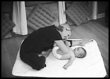 mom stretching while massaging baby