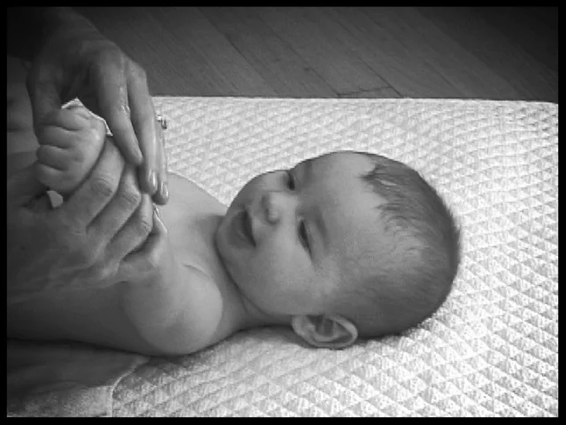 massaging baby's arms and hands