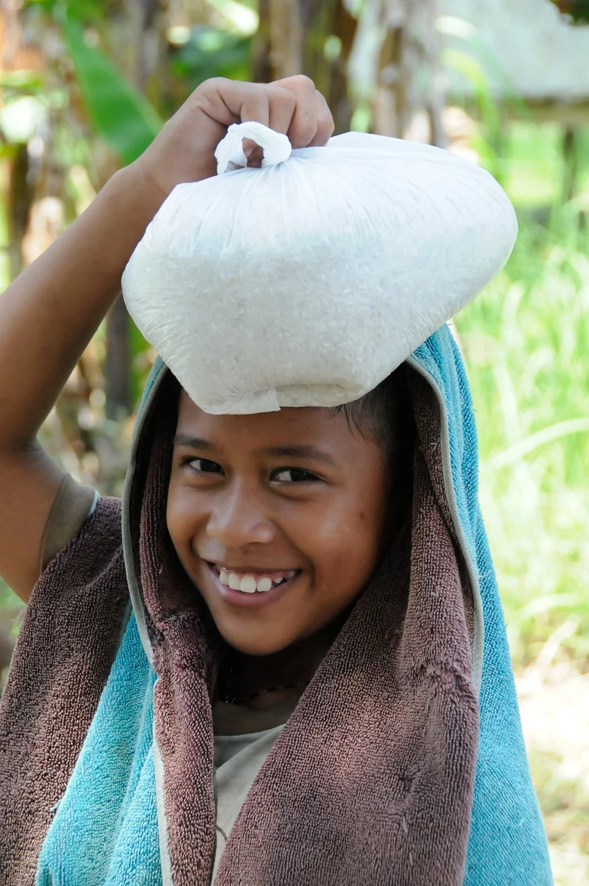 A-childs-smile-while-bringing-rice-home-for-lunch-Palawan-Island-the-Philippines-april-2011-by-Zarre-Ferragi-Global-RESIZED.jpg