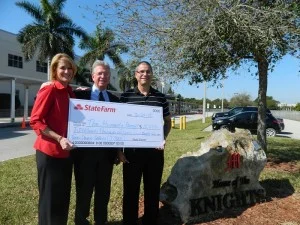 Melba Ballard and Jose Soto present a big check to the Humanity Project’s Bob Knotts