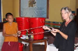 Tina Cornely teaches a young Nepal monk to turn trash into art-for-sale