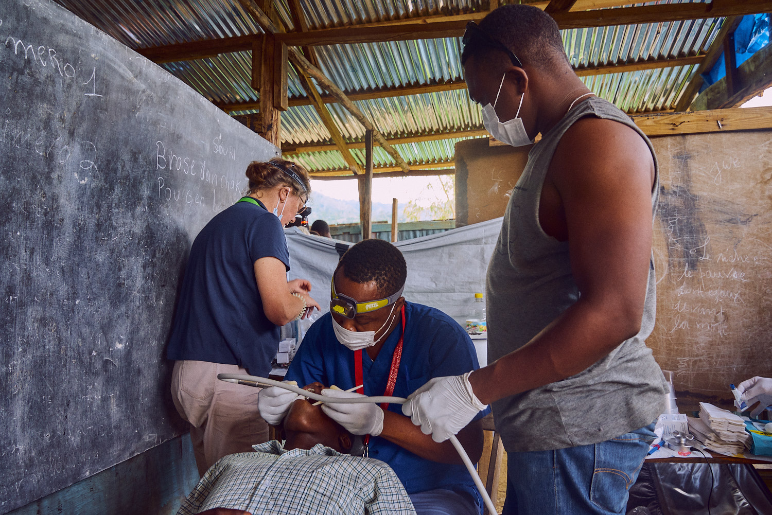 Cajouste Tony Jean-Pierre (center) preparing a student to receive fillings.