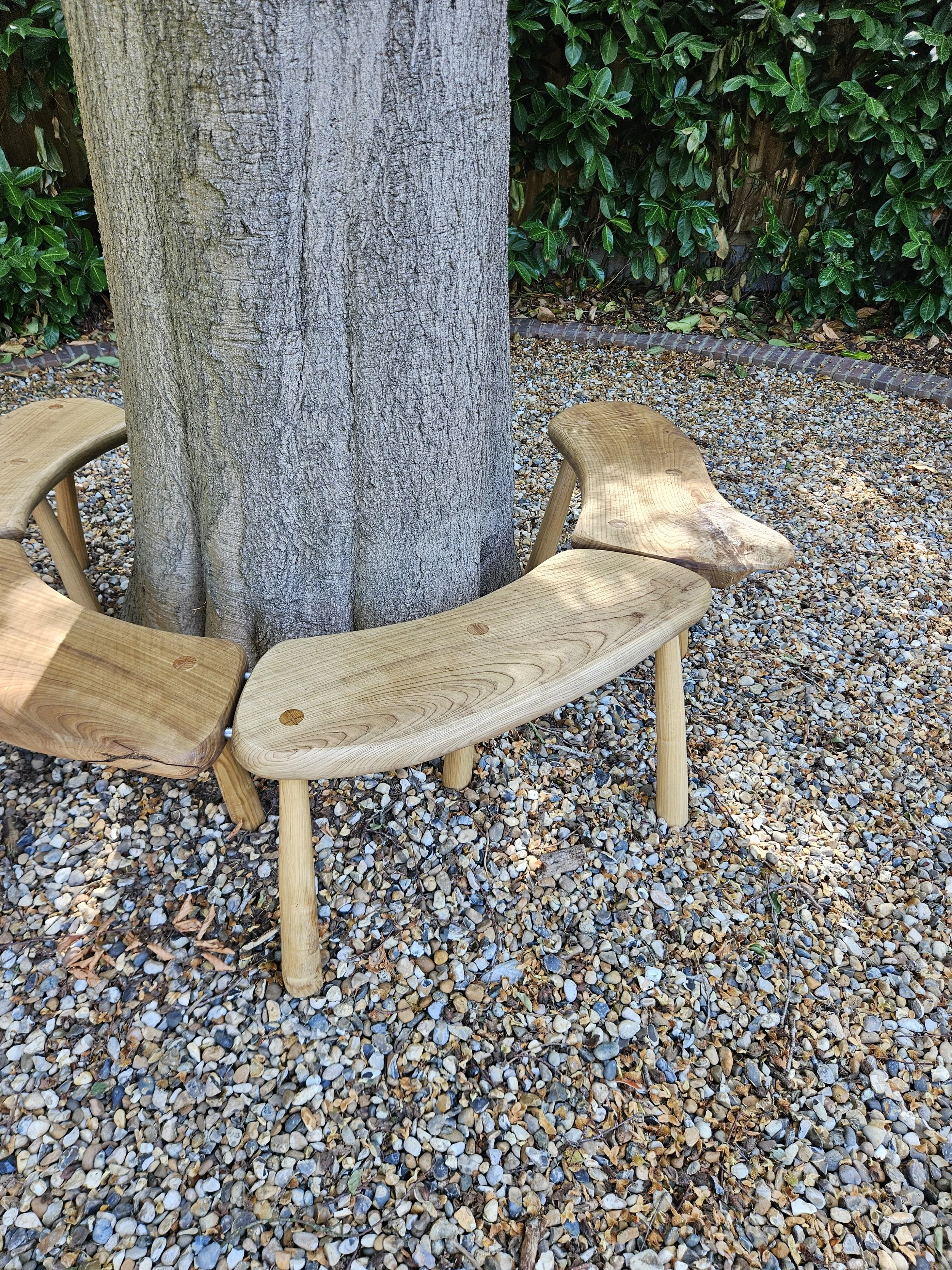 Sculptural wooden garden seating shaped around a mature tree trunk.