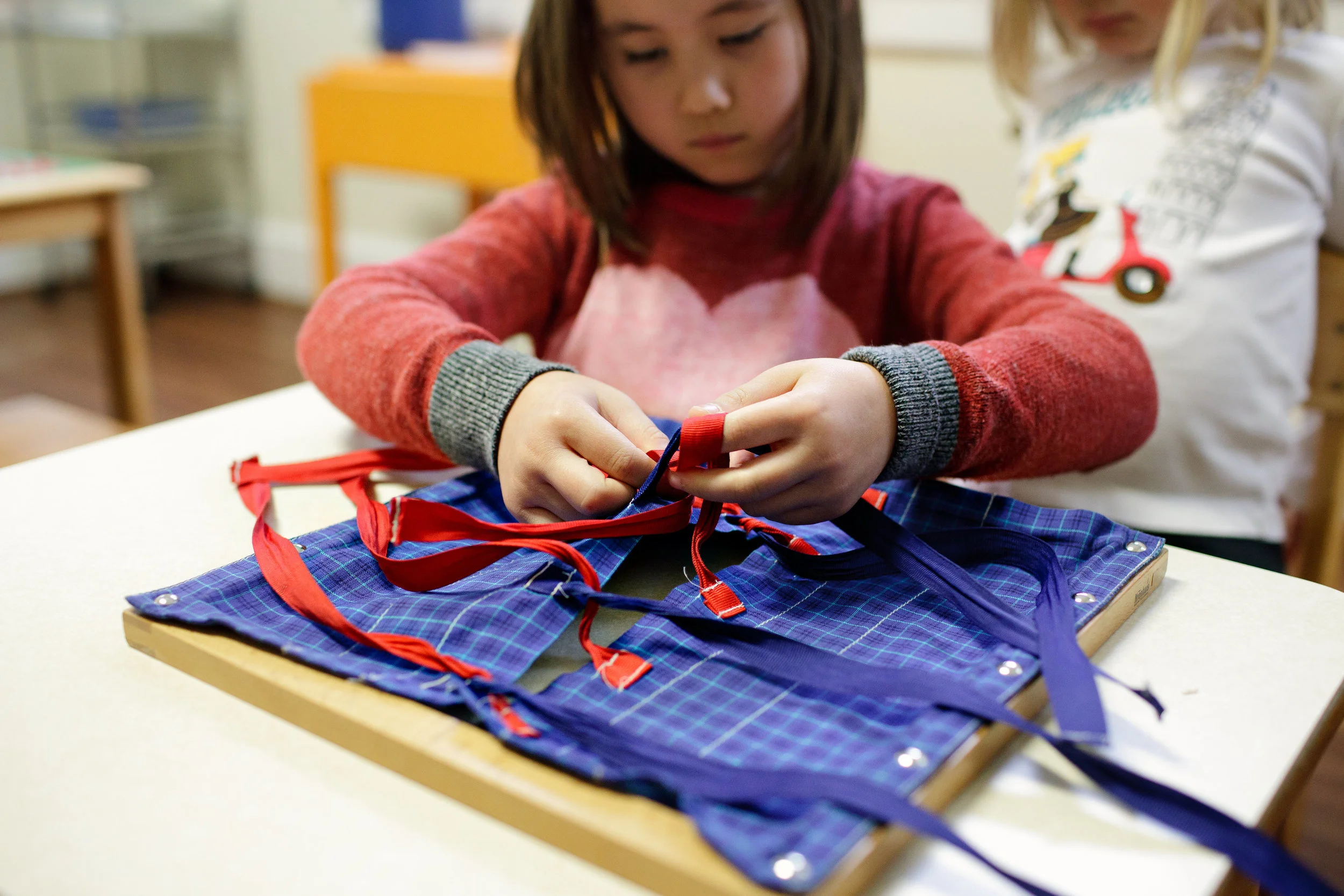 Practicing tying bows with the Bow Frame
