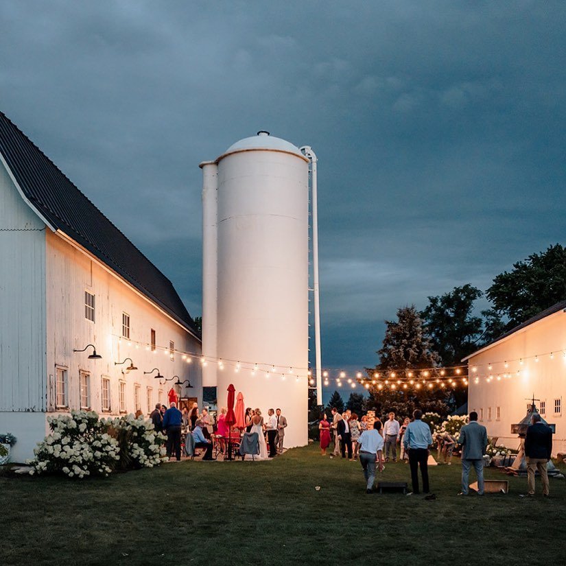 Our patio space is perfect for cocktails, laughs and games throughout your wedding day but there is always something extra special when it&rsquo;s under the string lights at night! #bluestemfarmandevents #barnwedding #realbarnwedding #summerwedding #