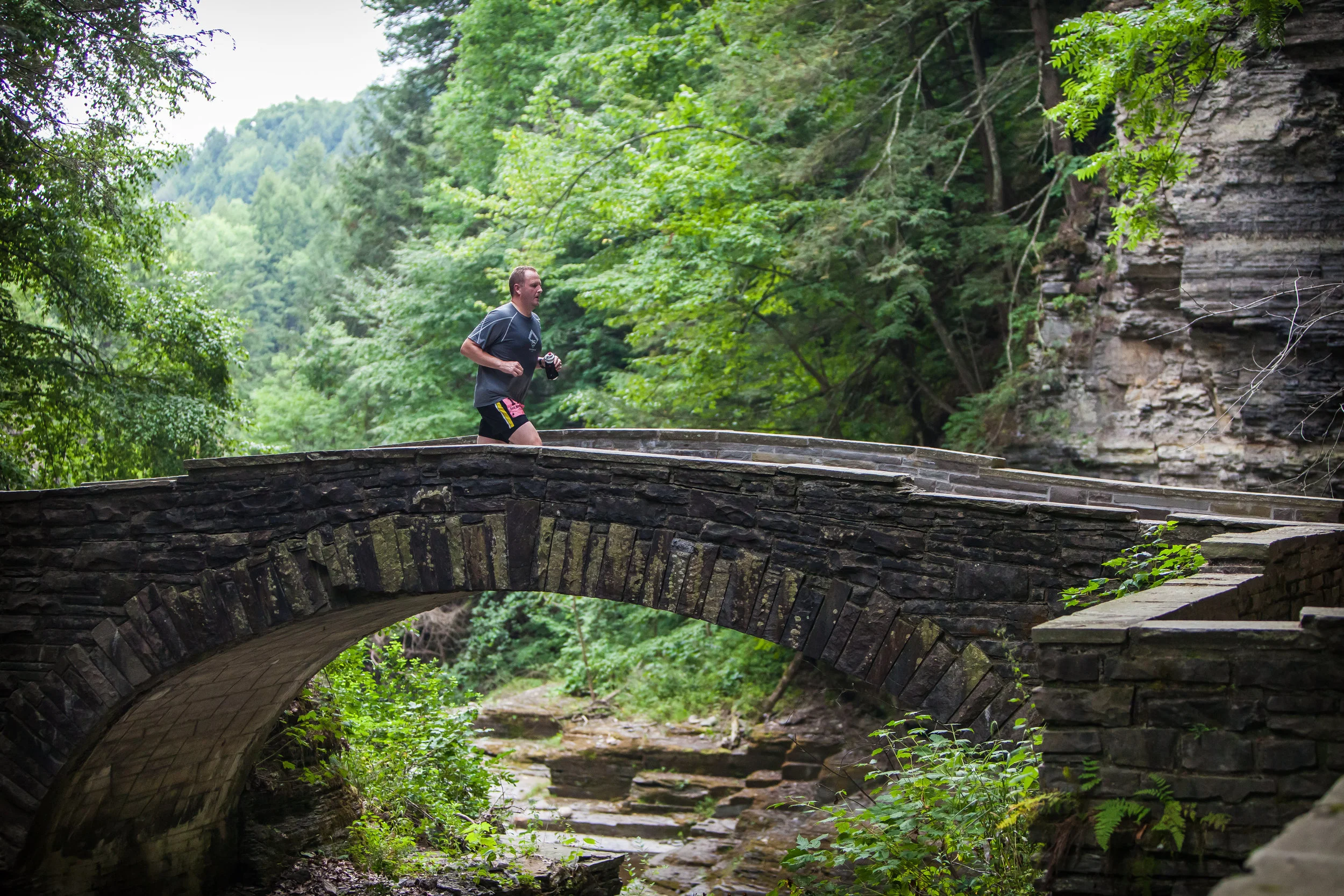 Runner on the trail above Lucifer Falls in Robert Treman State Park (Photo Credit: Red Newt Racing)