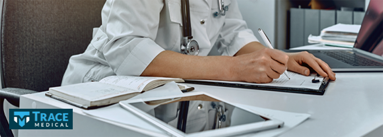 A doctor in a lab coat going over paperwork