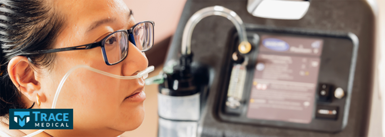 Woman with glasses using a portable oxygen concentrator