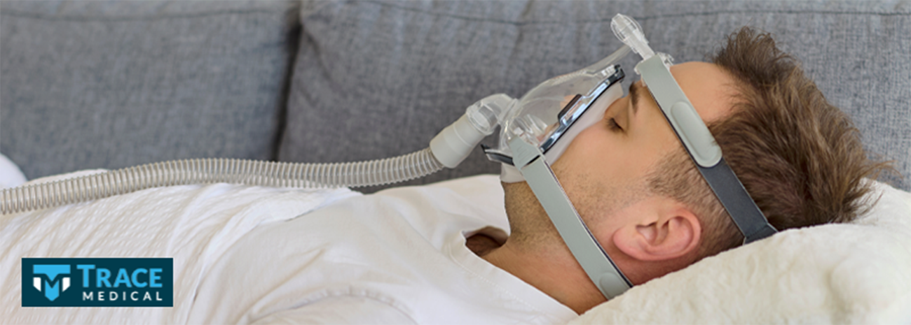 A man laying on his couch with a ventilator mask on