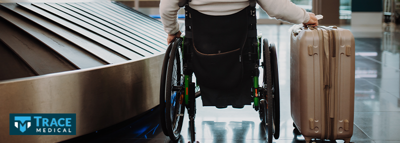 Man in a wheelchair pushing luggage in an airport