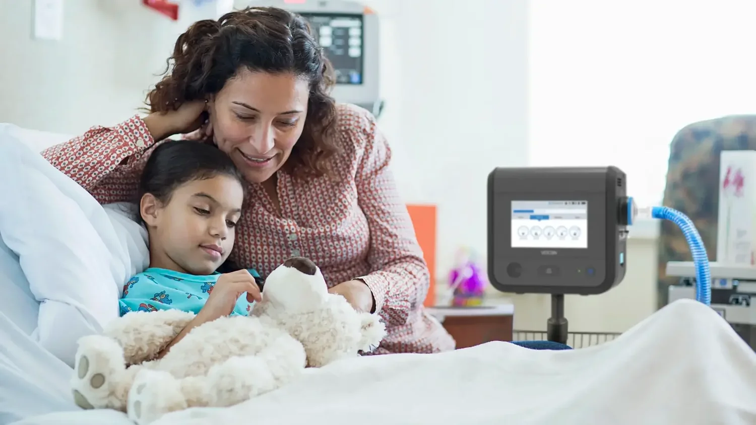 Mother and daughter at the bedside with a portable VOCSN ventilator