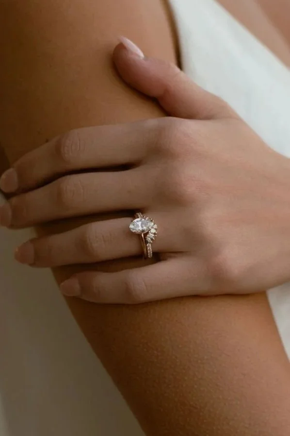 A close up of a bride's wedding ring set in 14k gold with diamonds in a unique setting, designed and made by Lady Cromer Jewelry. 
