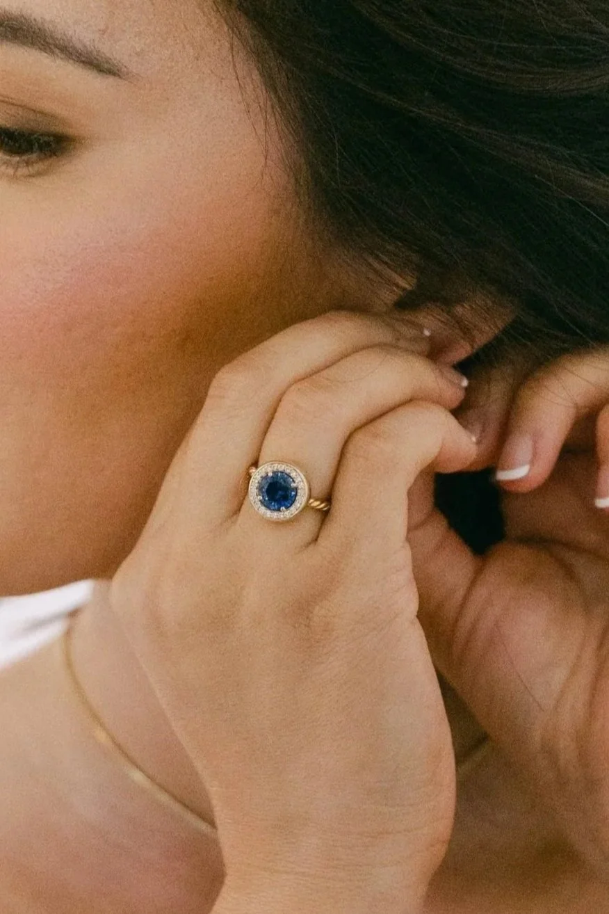 Custom made alternative engagement ring featuring a sapphire surrounded by a halo of diamonds. Photo by Adriana Michele Photography