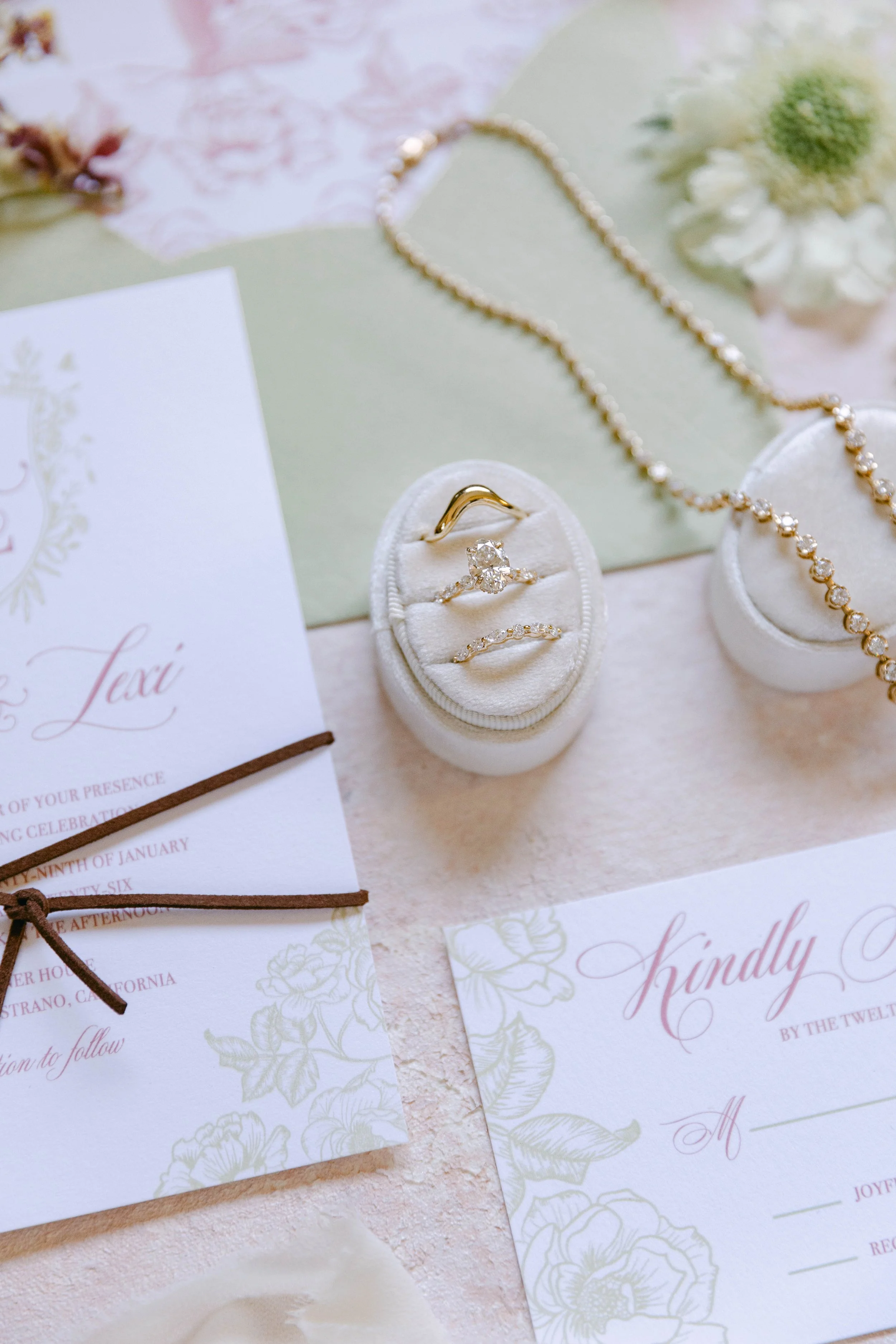 Wedding day flat lay featuring custom made Lady Cromer Jewelry engagement ring, and wedding bands. lab grown diamonds, 14k gold. diamond tennis necklace. Photography by Adriana Michele Photography