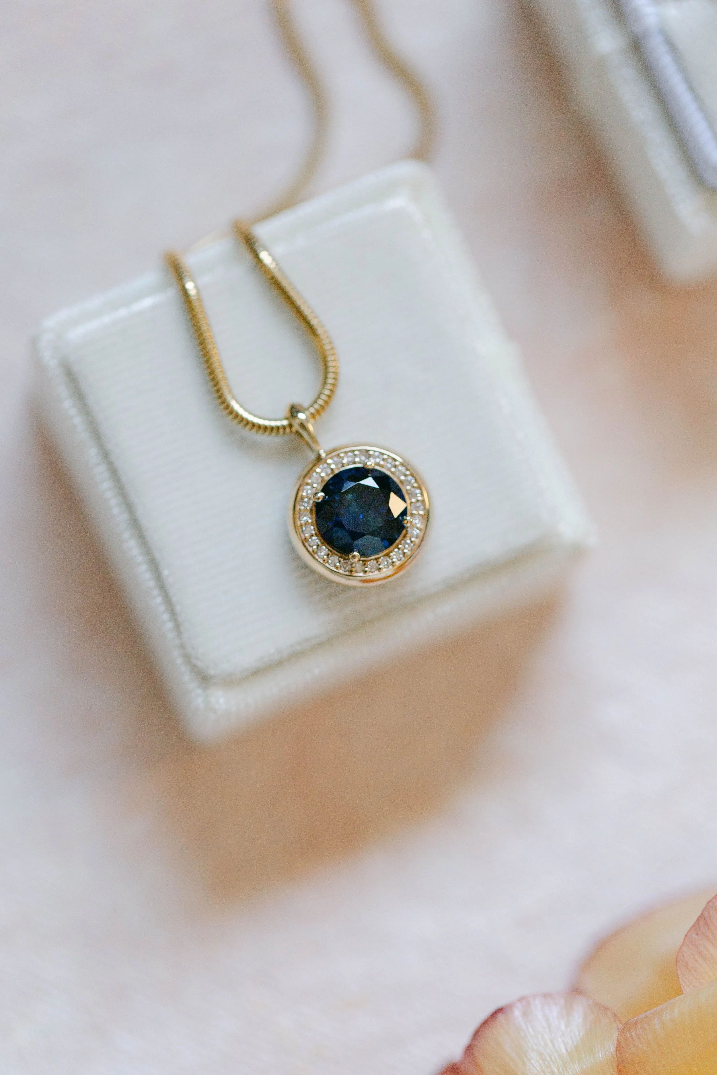 Custom made pendant with a lab grown sapphire and diamond halo, by Lady Cromer Jewelry. Photography by Adriana Michele Photography