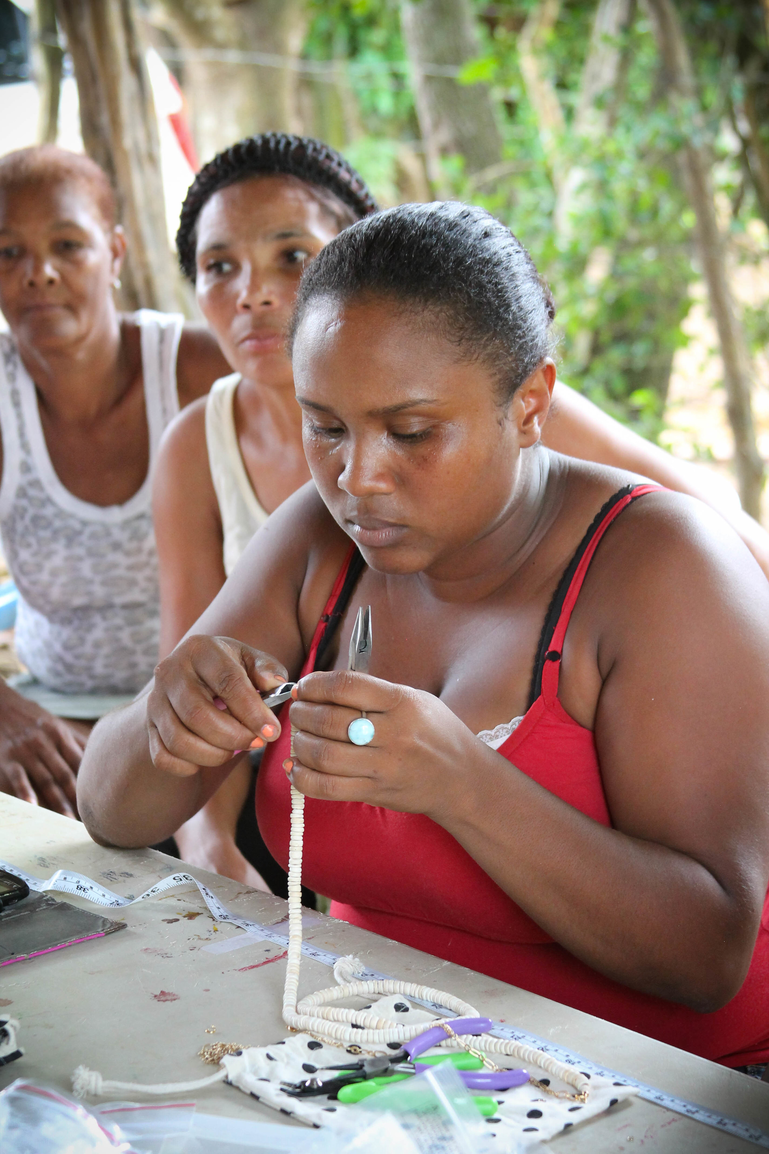 Elly making a triple chain coco bead necklace