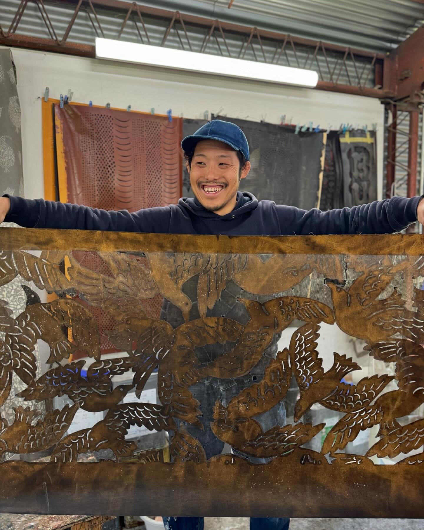 A favorite visit of our tour was the studio of &ldquo;katazome&rdquo; artist Ono-san. He&rsquo;s holding up a large hand-cut stencil of his with a gorgeous bird design&mdash;bold and full of movement. (I bought a top made from this fabric and it&rsqu