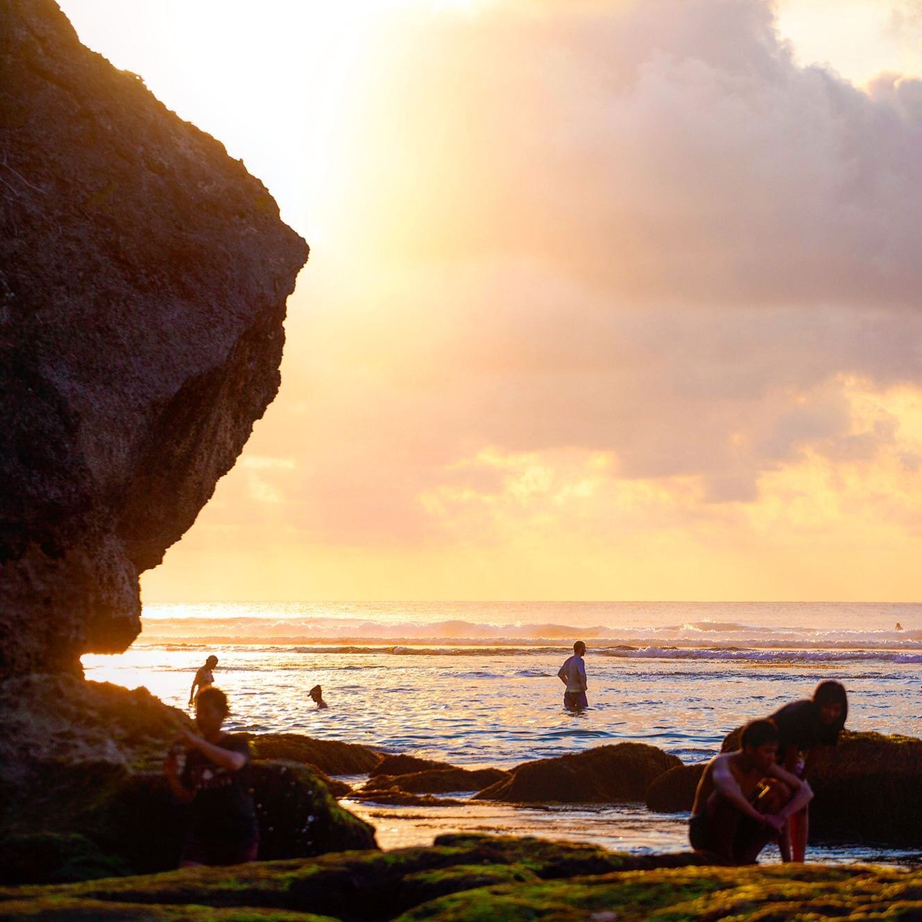 Bathers at the reefy base of the cliffs at Uluwatu - Bali, Indonesia.