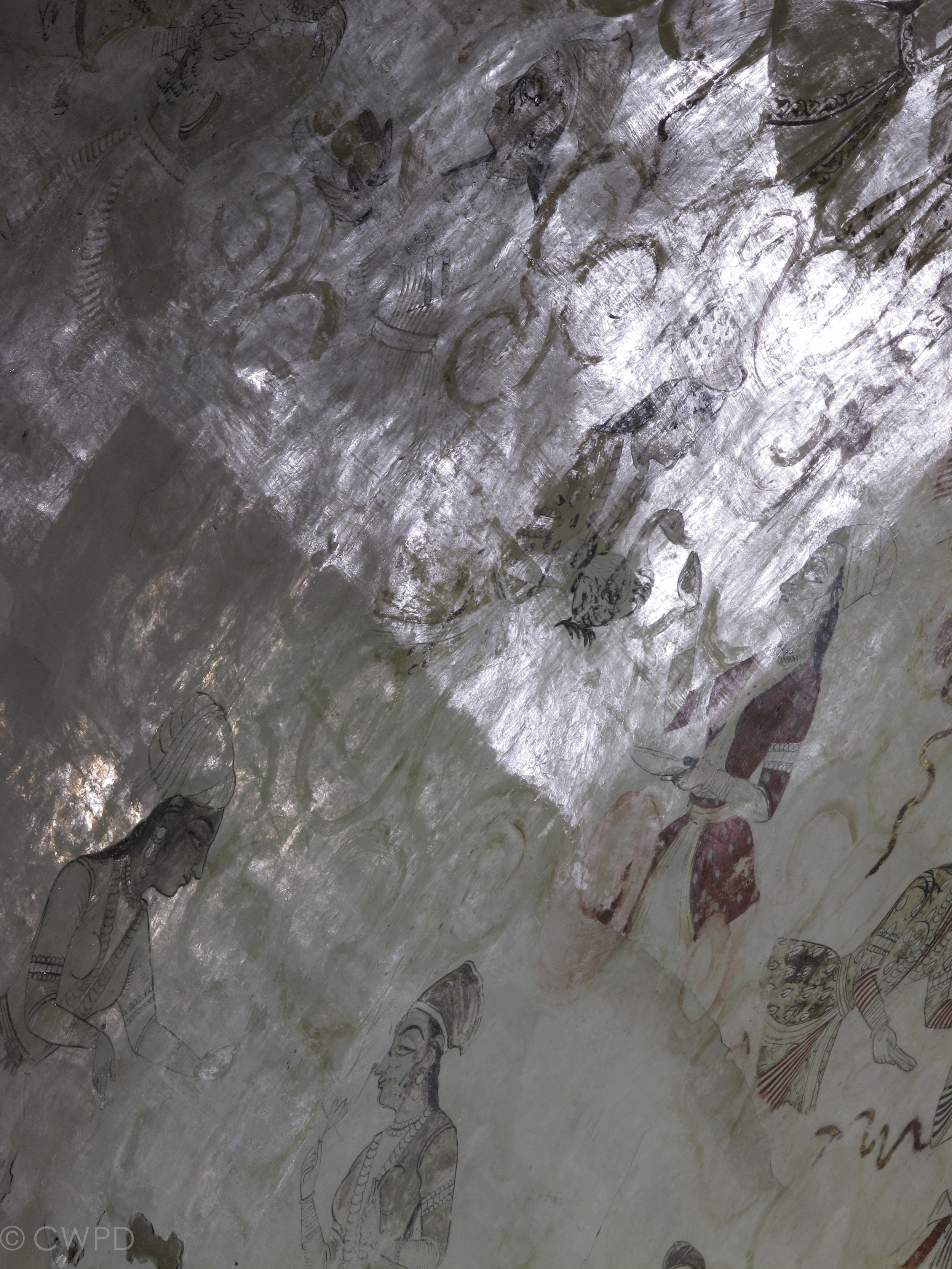  Detail of the vault during coating removal. The coating is clearly visible in the upper portion of the image, giving the paintings a glossy and discolored appearance. Where it has been removed in the bottom portion of the image, the originally matte