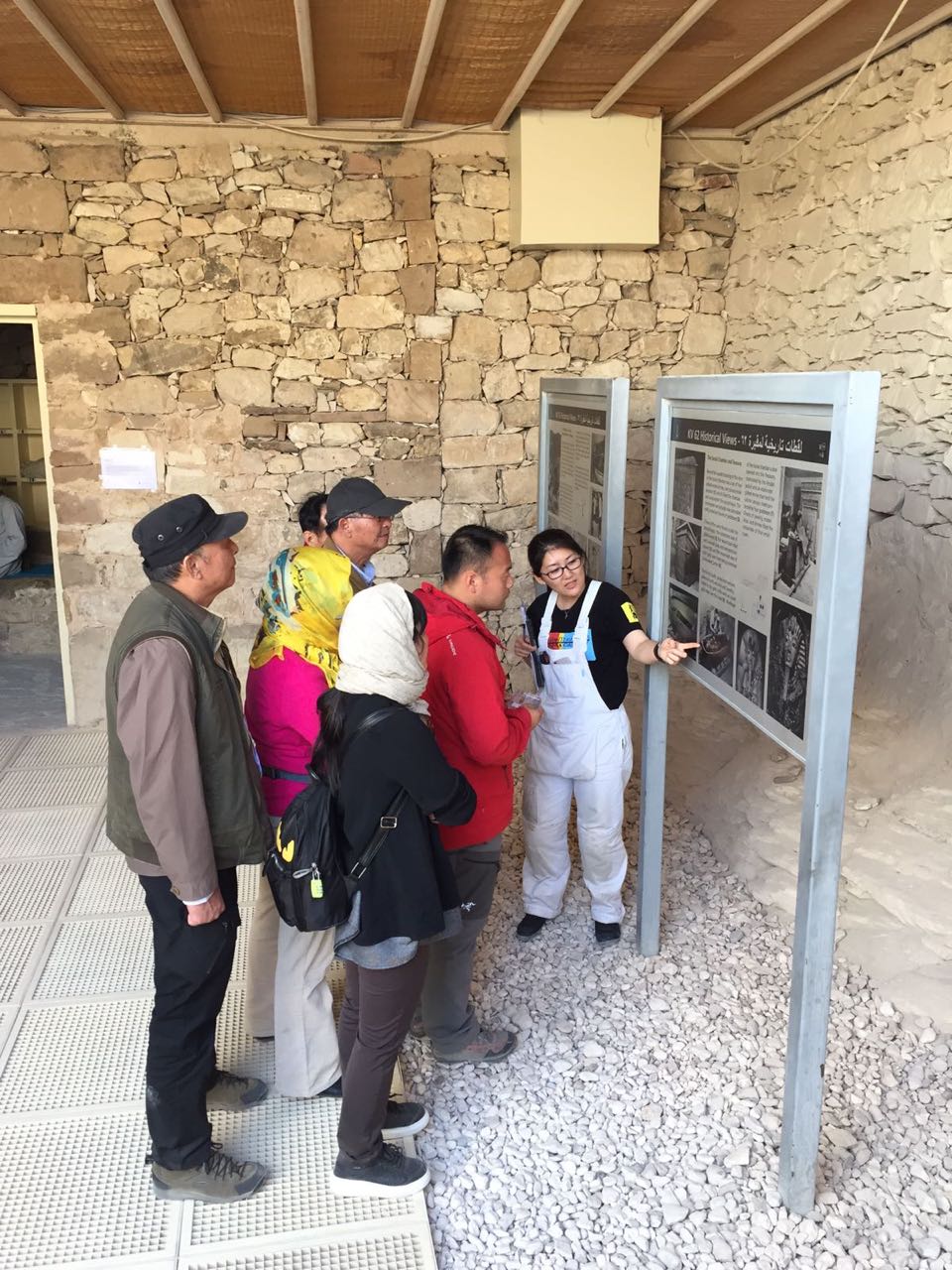  The entrance to KV 62, showing a group of tourists reviewing signage with a member of the conservation team.&nbsp;  Image © J. Paul Getty Trust, 2017 