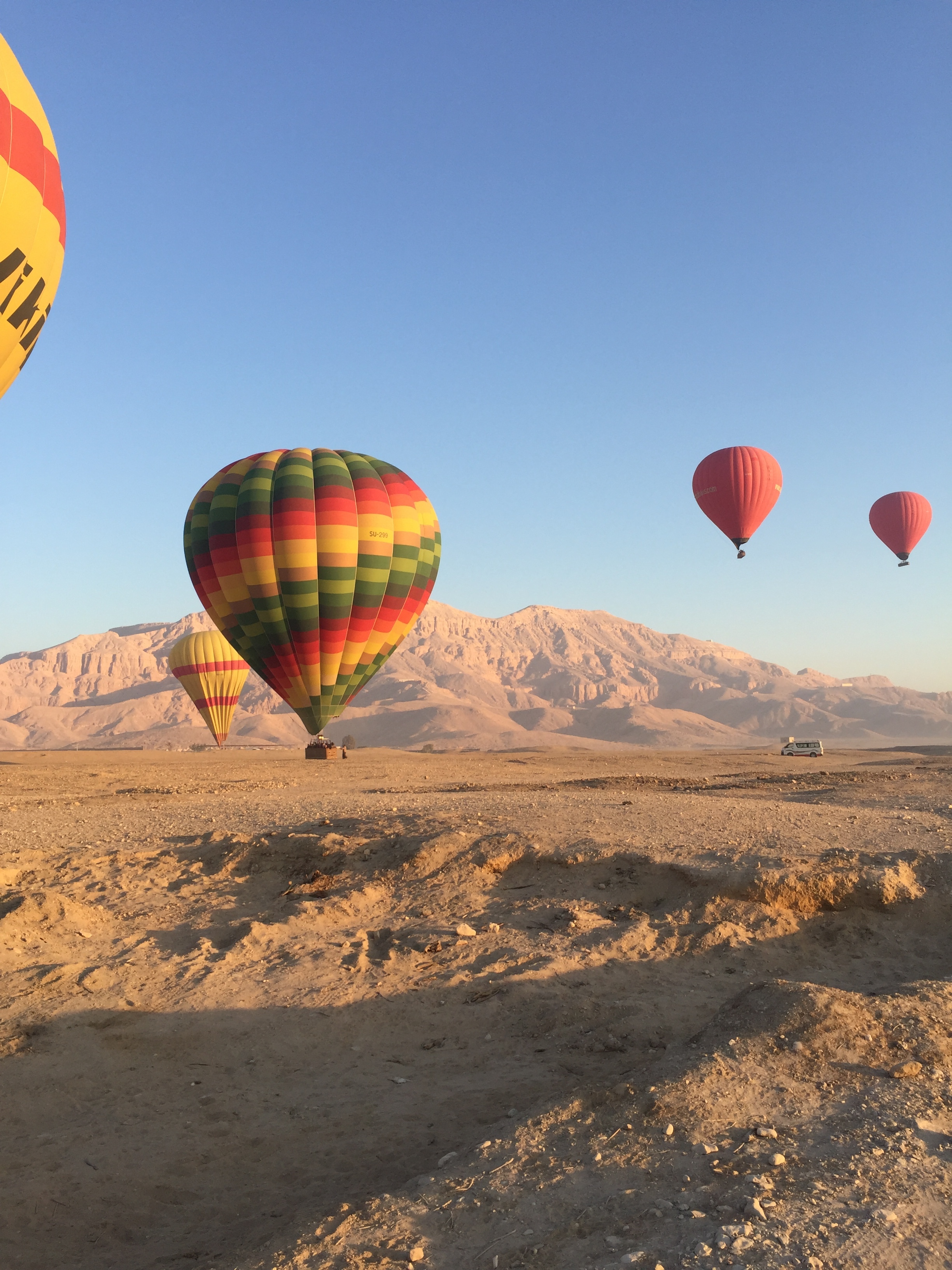  Hot air balloons landing in the desert south of the sacred mountain,&nbsp;El Qurn, where the Valleys of the Nobles, Queens and Kings are located.&nbsp;  Image © Katey Corda, 2017 