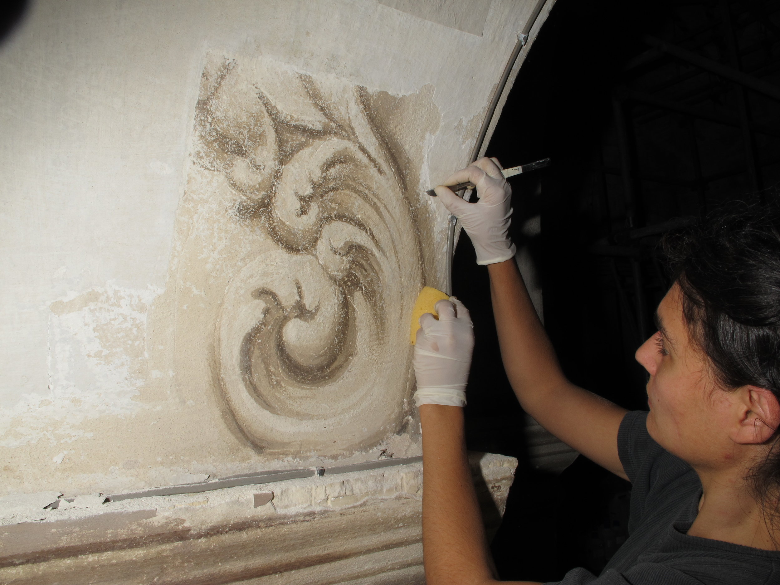  Uncovering a section of wall painting obscured by layers of limewash.  Image © Courtauld CWPD 