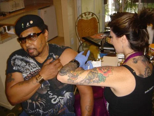 Friday Jones tattooing Aaron Neville