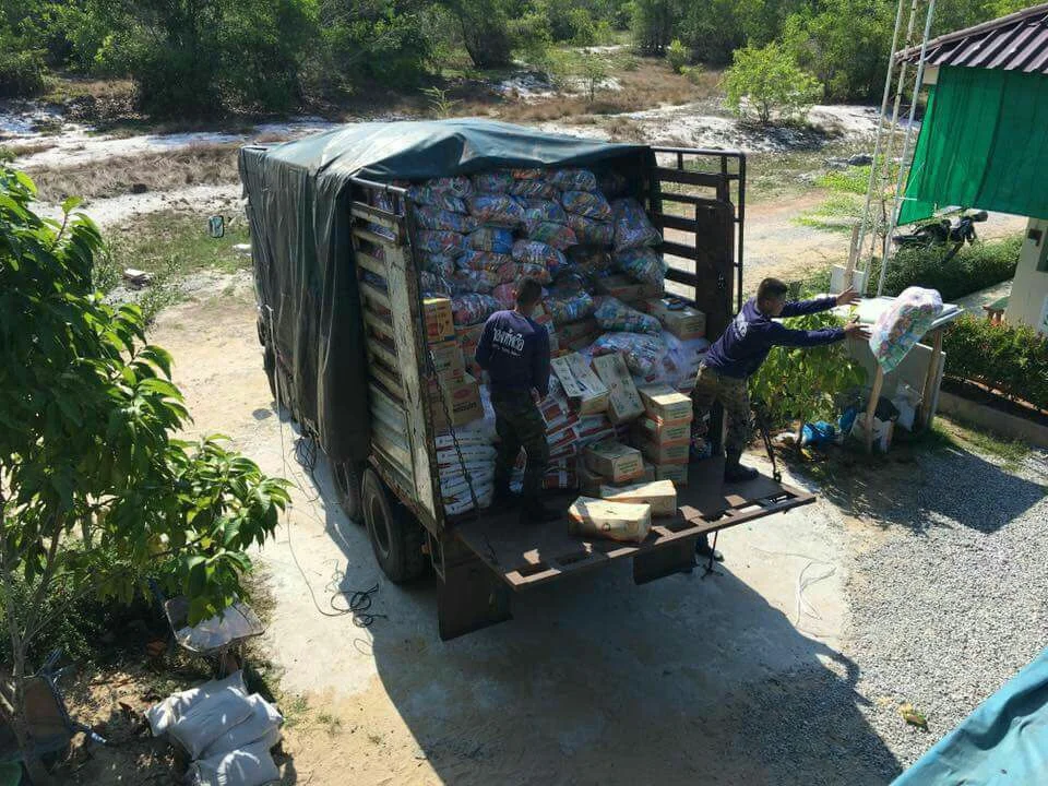 Military personnel unloading dry foods at Narathiwat Youth Training Center.